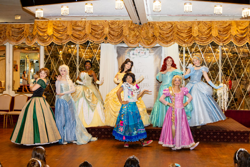 Princesses pose on the stage after a dance at the Astoria Princess Ball