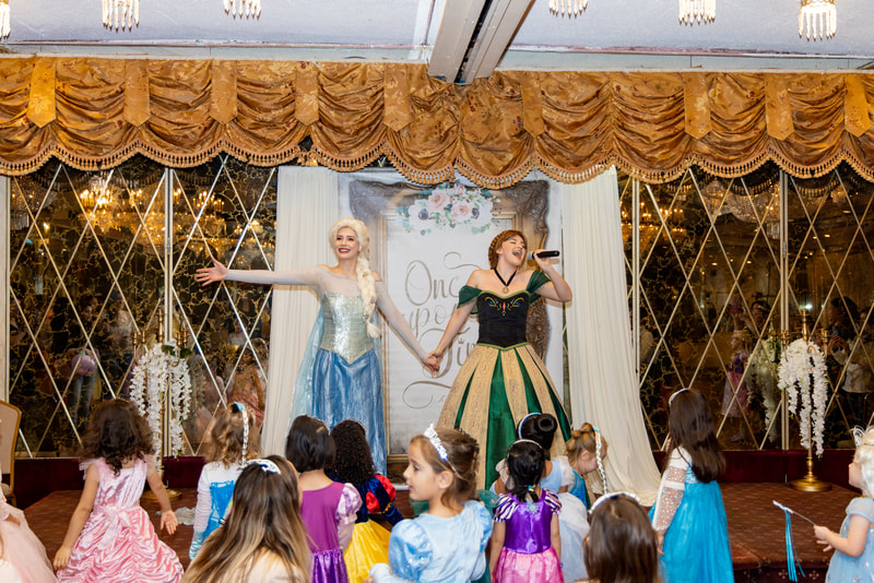 Elsa and Anna sing to the children at the Astoria Princess Ball