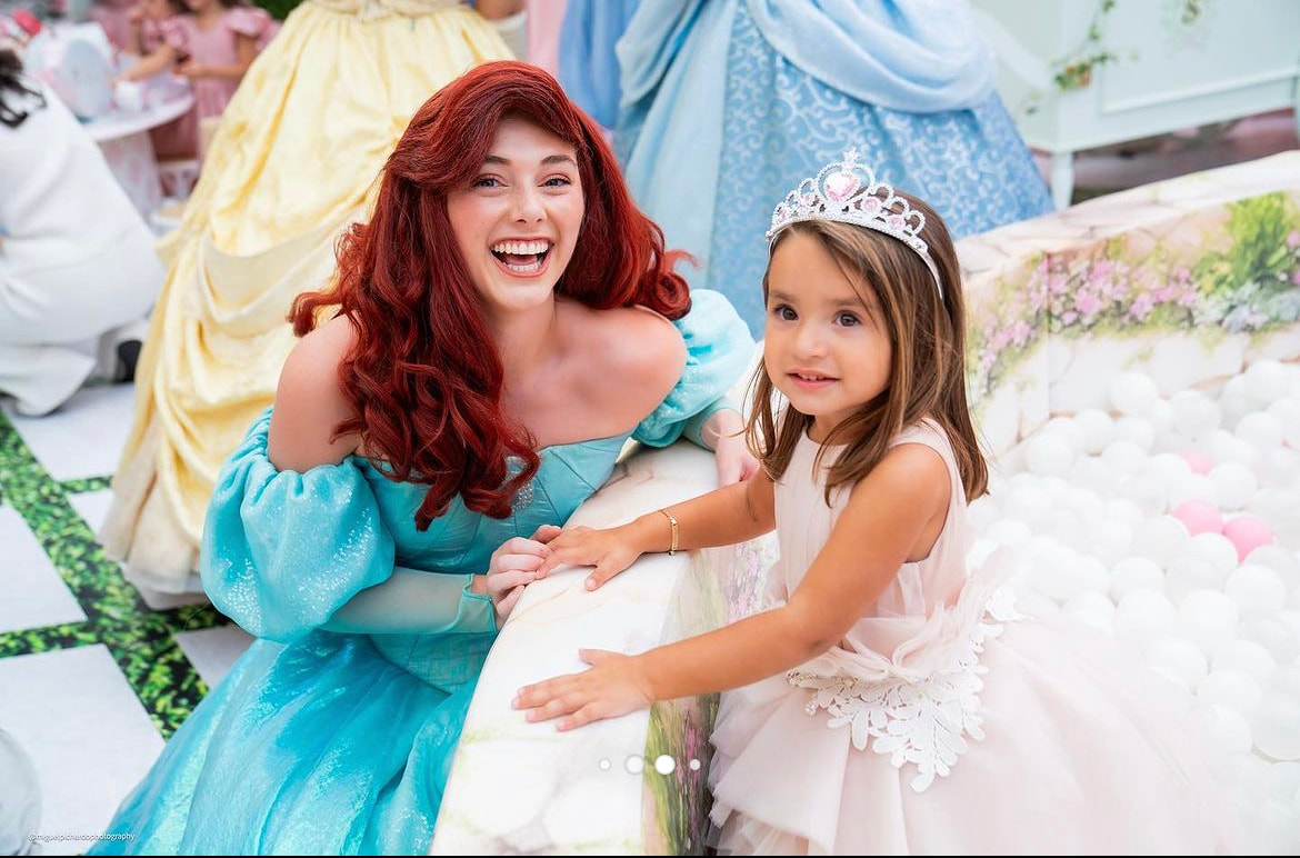 Ariel and the birthday girl giggle together at her princess party