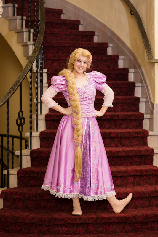 Rapunzel poses on the castle stairs at the royal princess ball