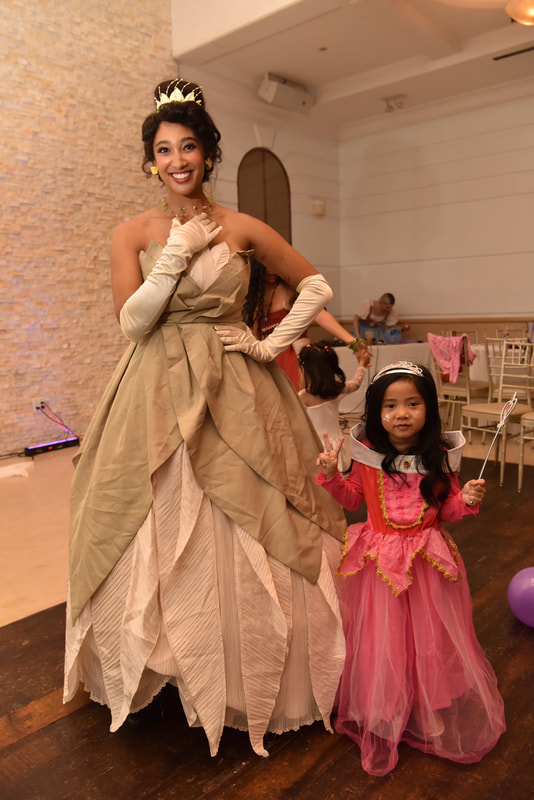 Princess Tiana and a little princess dance at the royal ball 