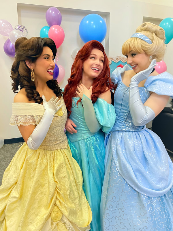 Cinderella, Belle, and Ariel laugh and smile at a little princess party in New York City. 